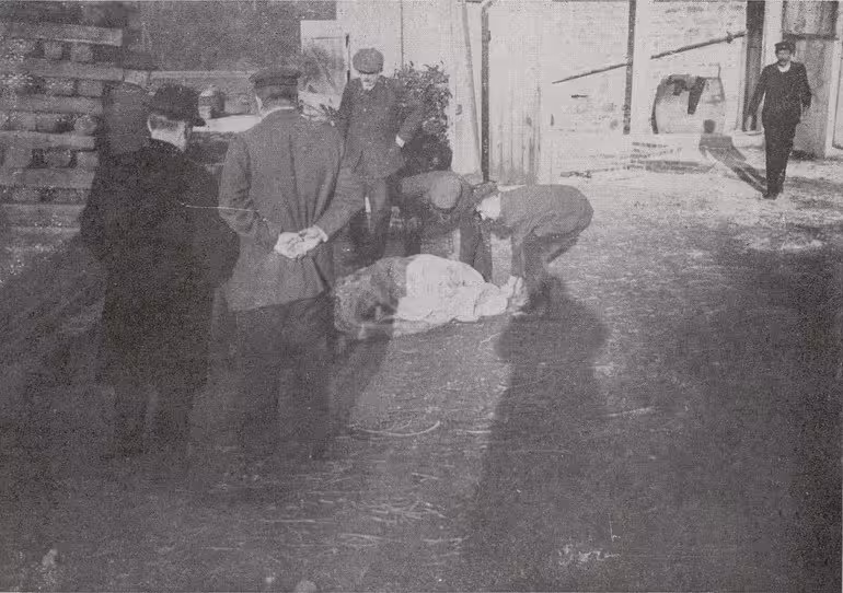 Le corps est déposé dans la cour de l'usine, pour procéder aux constatations. Photographie de presse, Le Monde Illustré (avril 1914) : Le corps de Louis Cadiou déposé dans la cour de l'usine de la Grande Palud pour les constatations judiciaires